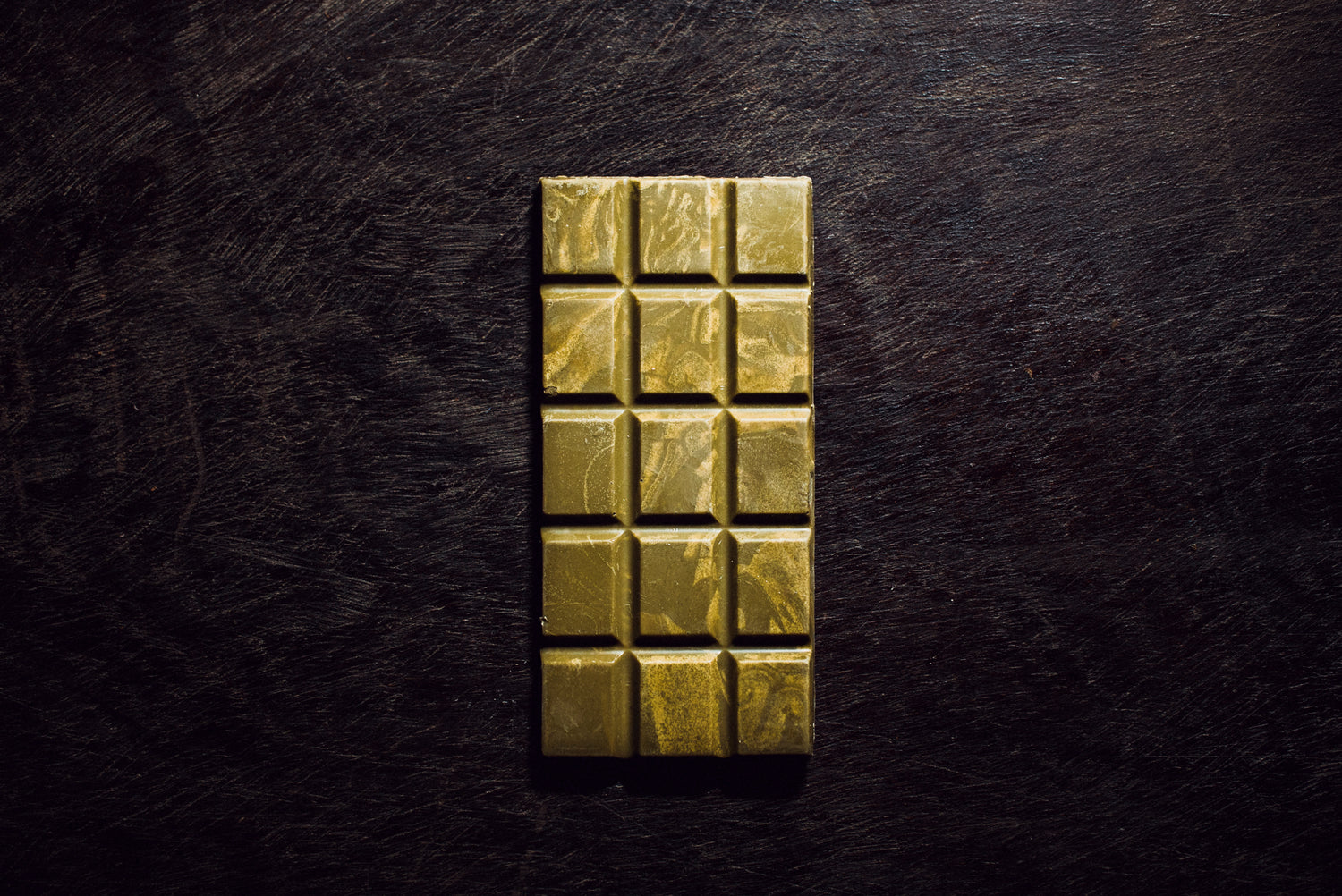 Handcrafted white chocolate bar with 36% cacao and matcha on traditional Guatemalan textile background
